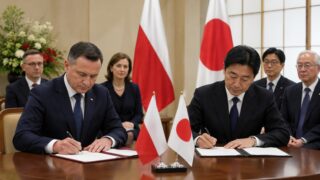 Podpisanie porozumienia przy flagach Polski i Japonii