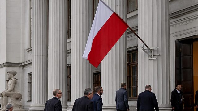 Polska flaga przy kolumnadzie gmachu instytucji państwowej