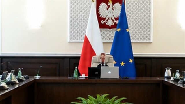 Sala instytucji publicznej z polskim godłem i flagami