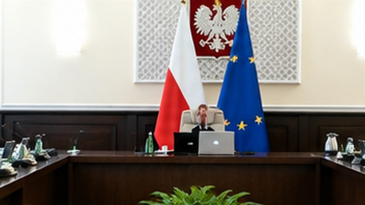 Sala instytucji publicznej z polskim godłem i flagami