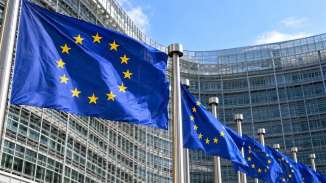 Flagi Unii Europejskiej przed instytucją w Brukseli