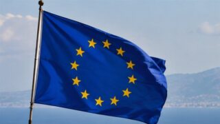 Flaga Unii Europejskiej na tle nieba i morza; ilustracja procesu rozszerzania Unii