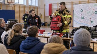 Ratownicy pokazują mieszkańcom wyposażenie kryzysowe i mapę schronienia