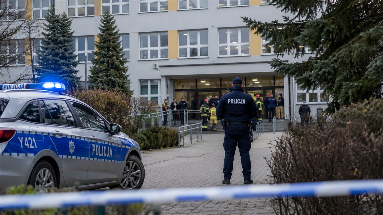 Budynek szkoły z policyjną interwencją i służbami przy wejściu