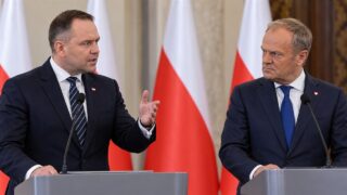 Donald Tusk i Karol Nawrocki podczas konferencji prasowej na tle polskich flag