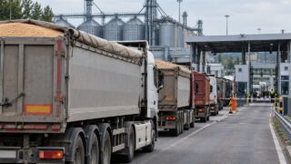 Ciężarówki z ładunkiem w pobliżu silosów i infrastruktury zbożowej