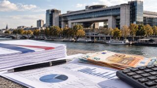 Dokumenty budżetowe, kalkulator i banknoty euro na tle francuskiego Ministerstwa Gospodarki i Finansów w Bercy