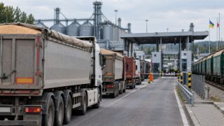 Ciężarówki z ładunkiem zboża czekają przy punkcie kontrolnym obok terminala zbożowego